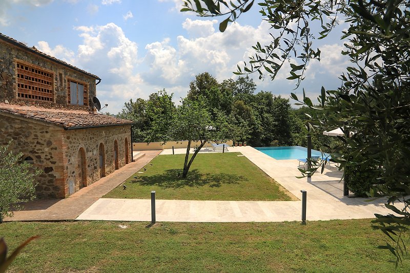 Una villa con piscina, giardino e vista sulla città.