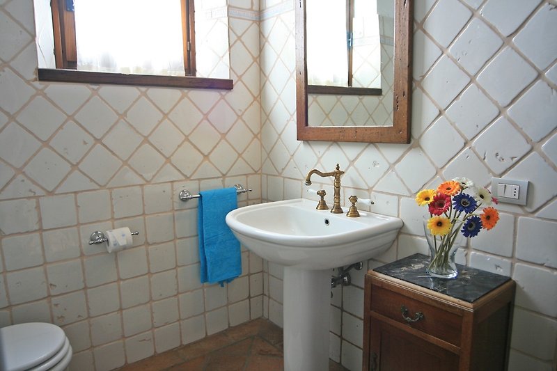 Un bagno viola con un lavandino, uno specchio e un rubinetto.
