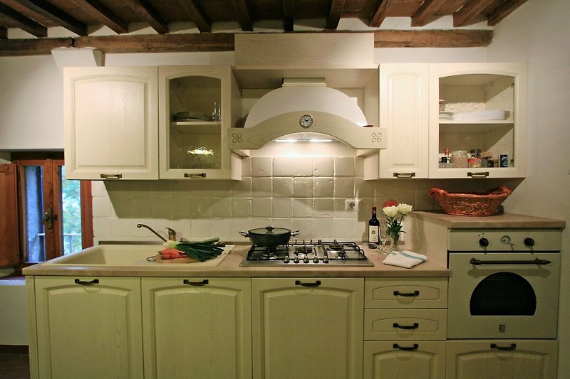 Una cucina moderna con mobili bianchi e elettrodomestici in acciaio.