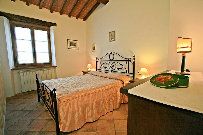 Una camera da letto con un letto in legno e una lampada da tavolo.