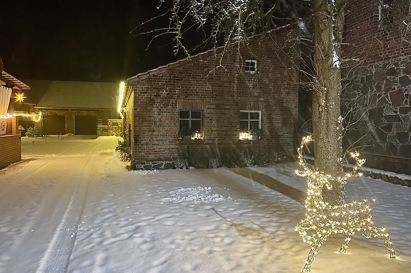 Winterlandschaft mit Schnee, Beleuchtung und festlicher Dekoration.