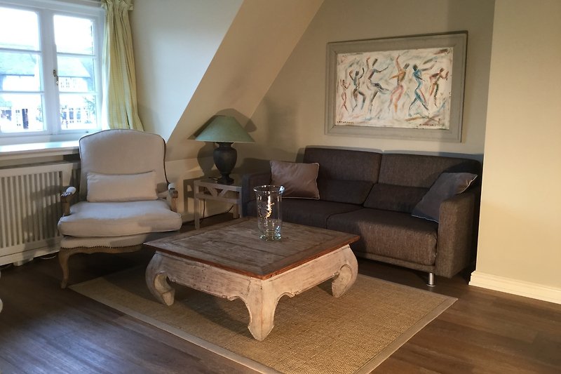 Wohnzimmer mit brauner Couch, Holzmöbeln, Tisch, Lampe und Bilderrahmen. Gemütliche Atmosphäre.