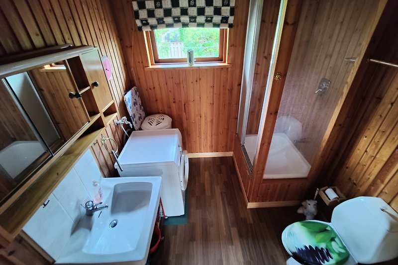 Badezimmer mit Spiegel, Waschbecken und Holzdetails.