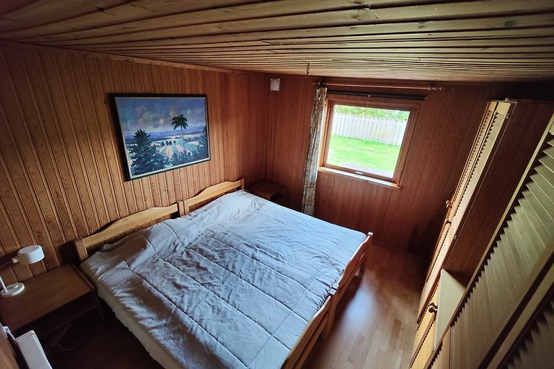 Holzhaus mit gemütlichem Schlafzimmer und Tisch.