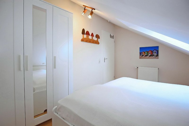 erstes Schlafzimmer mit Doppelbett und Kleiderschrank