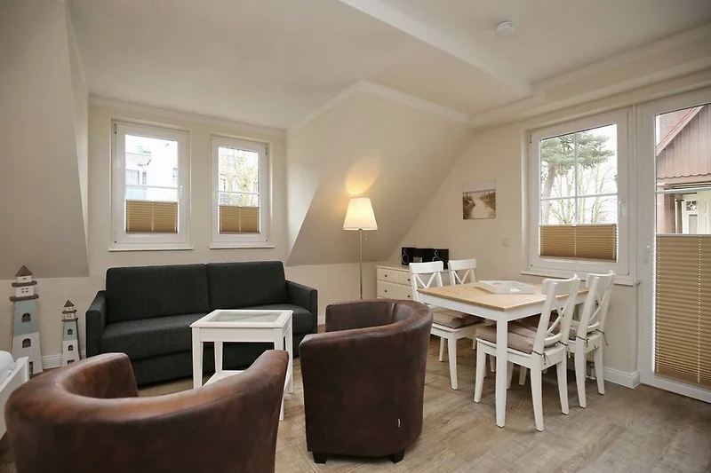 Wohnzimmer mit Schlafcouch und Esstisch