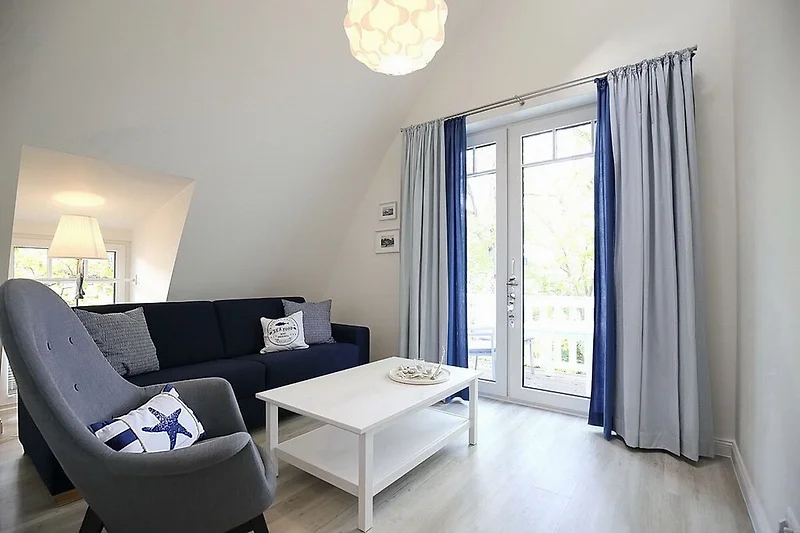 Wohnzimmer mit Schlafcouch und Sessel