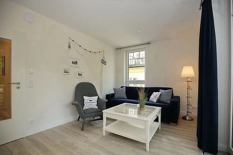 Wohnzimmer mit Schlafcouch und Sessel