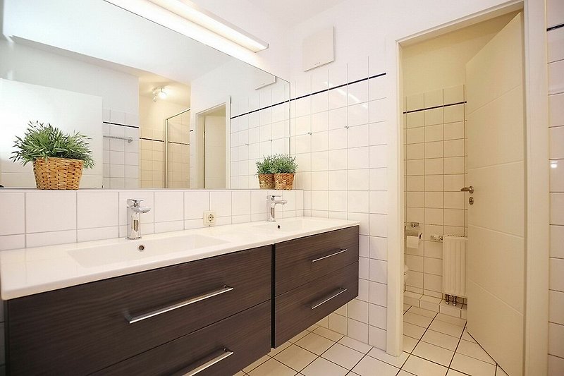 Badezimmer mit doppeltem Waschbecken und separatem WC