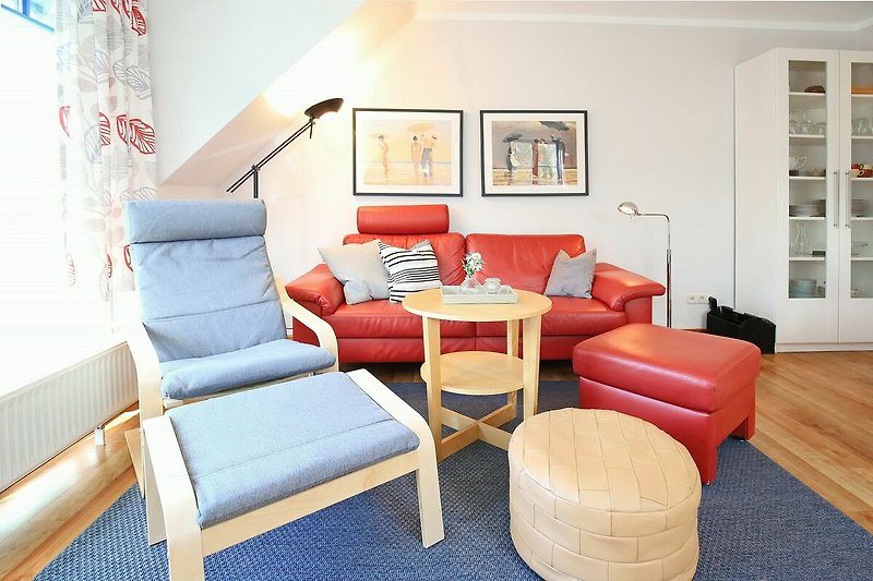 Wohnzimmer mit Sofa, Relaxsessel und Hockern