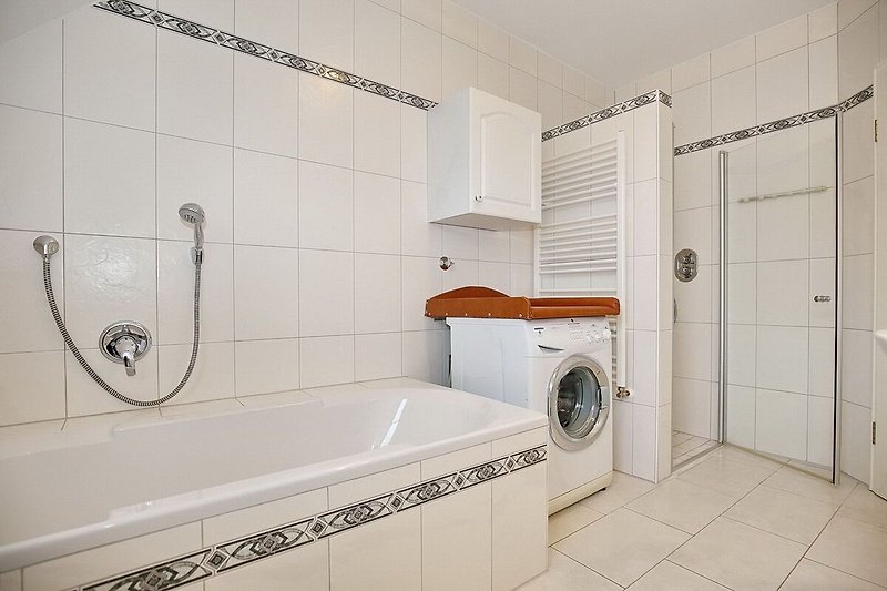 Badezimmer mit ebenerdiger Dusche, Wanne, Waschmaschine und Wickelaufsatz
