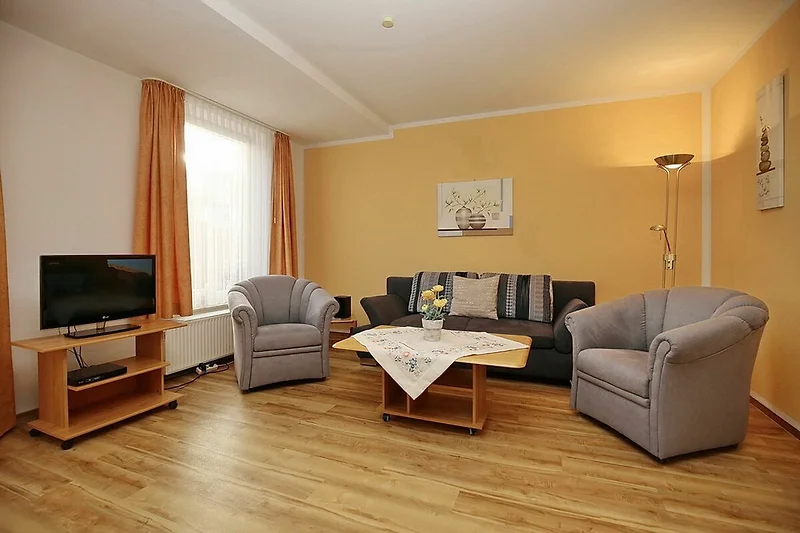 Wohnzimmer mit Schlafsofa und Sesseln