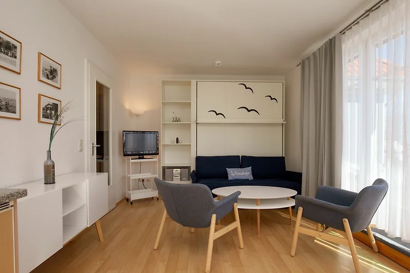 Wohnzimmer mit Schlafcouch und Sesseln