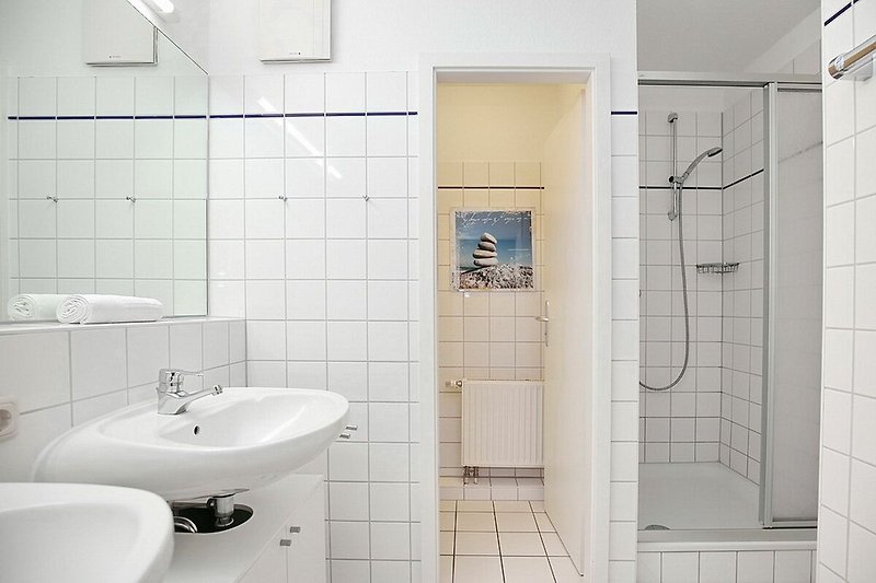 Badezimmer mit Dusche, Waschbecken und separatem WC