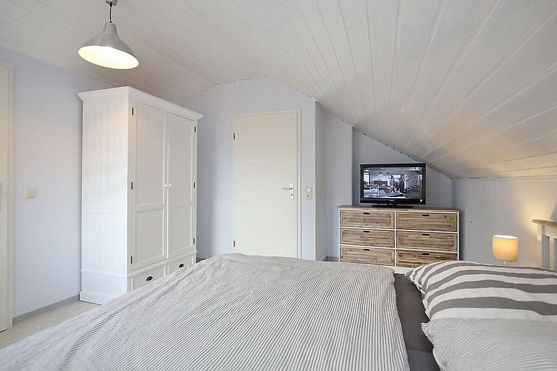 zweites Schlafzimmer mit Doppelbett, Kleiderschrank, Kommode und TV