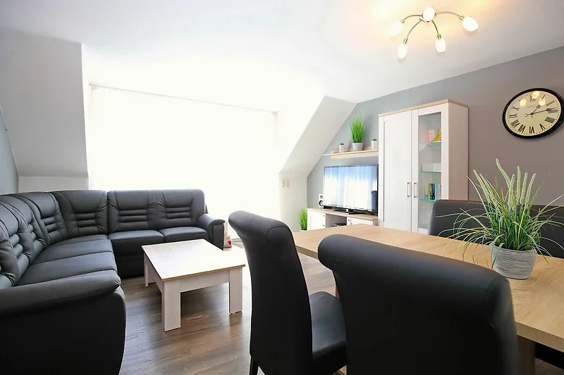 Ecksofa mit TV und Esstisch im Wohnzimmer