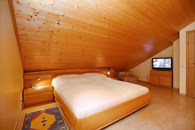 zweites Schlafzimmer mit Doppelbett und TV