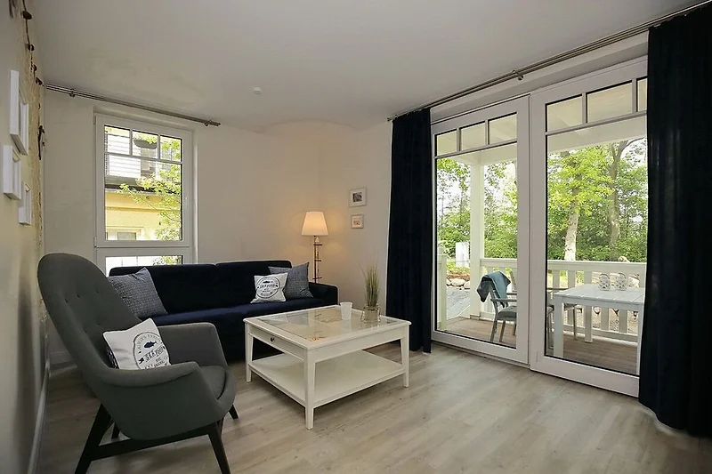 Wohnzimmer mit Schlafcouch und Sessel