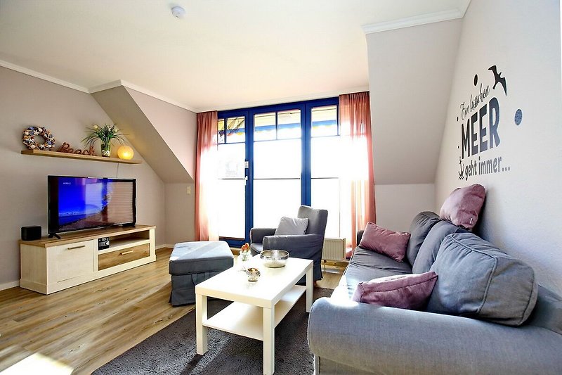 Wohnzimmer mit Sofa, Sessel und TV