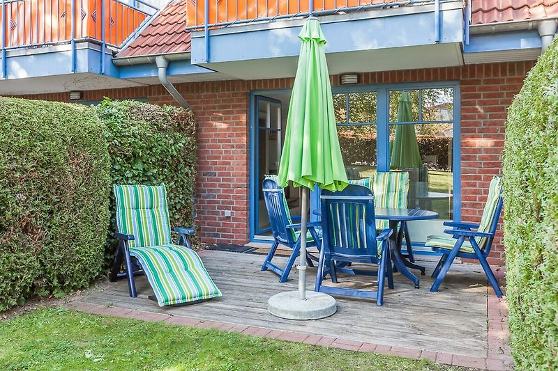 Terrasse mit Gartenmöbeln und Liegestuhl