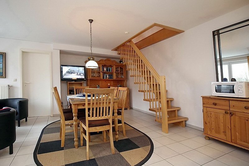 Wohnzimmer mit Esstisch und Treppenaufgang