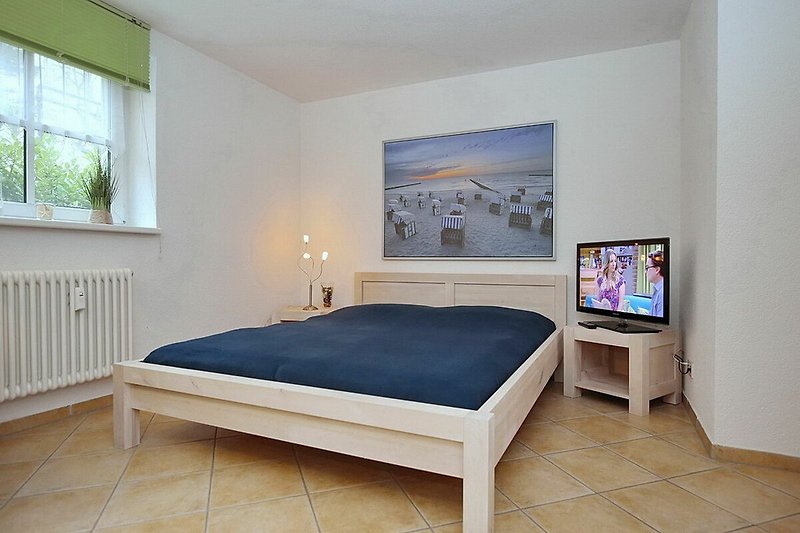 Wohnzimmer mit Doppelbett und TV