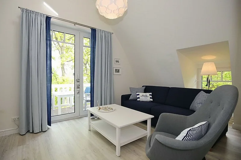 Wohnzimmer mit Schlafcouch und Sessel