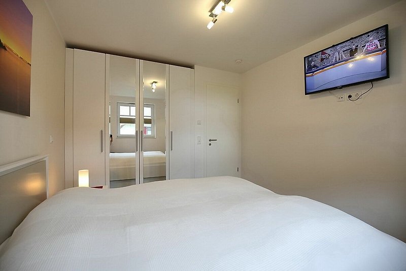1. Schlafzimmer mit Doppelbett, TV und Kleiderschrank
