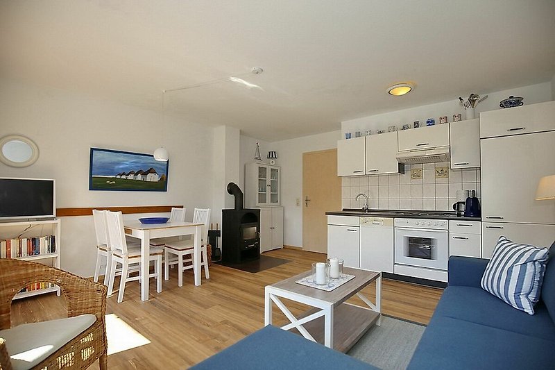 Wohnzimmer mit Sofaecke, Essbereich, Küche, Kamin und TV
