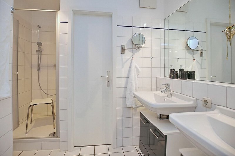 Badezimmer mit doppeltem Waschbecken, Dusche und separatem WC