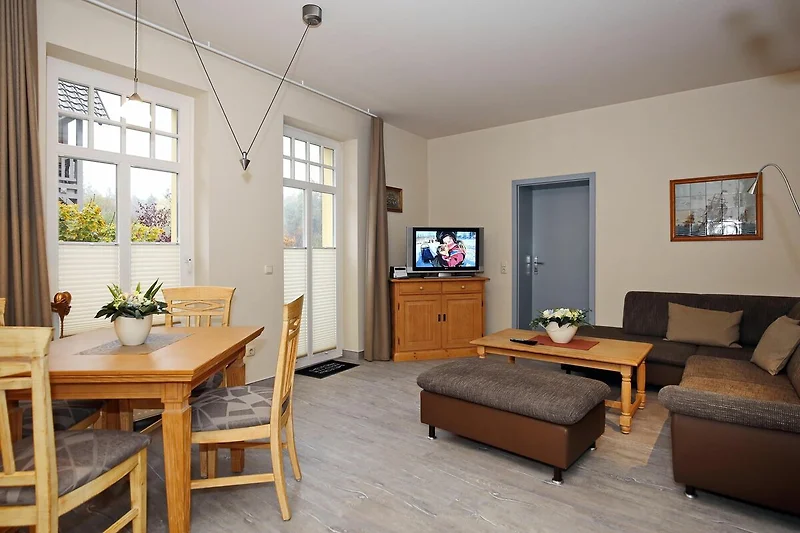 Wohnzimmer mit Esstisch, Couch und TV