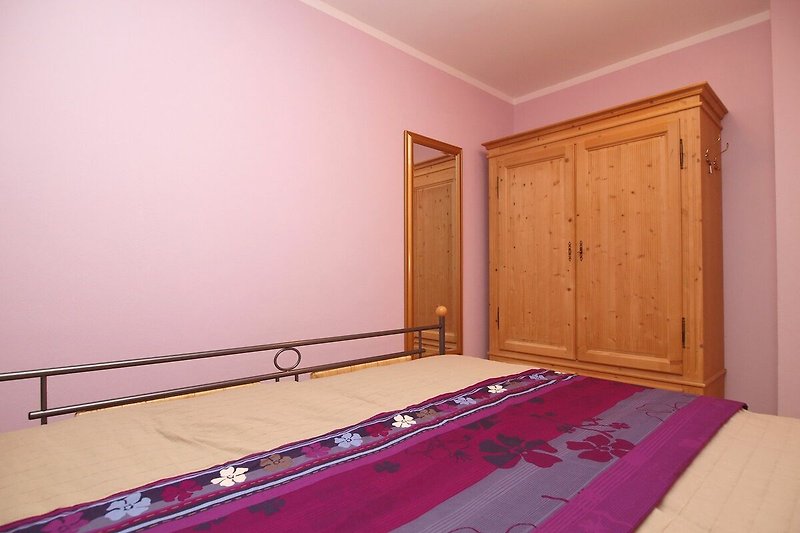 Schlafzimmer mit Doppelbett und Kleiderschrank