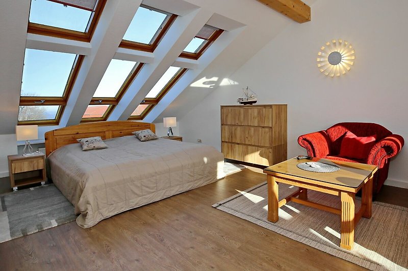 Schlafzimmer mit Doppelbett, Sessel und Kommode