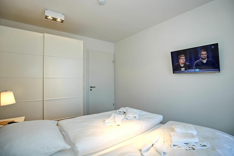 Schlafzimmer mit Kleiderschrank und TV