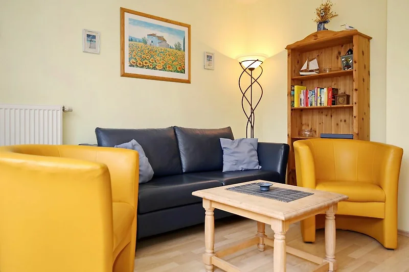 Wohnzimmer mit Schlafcouch und Sesseln