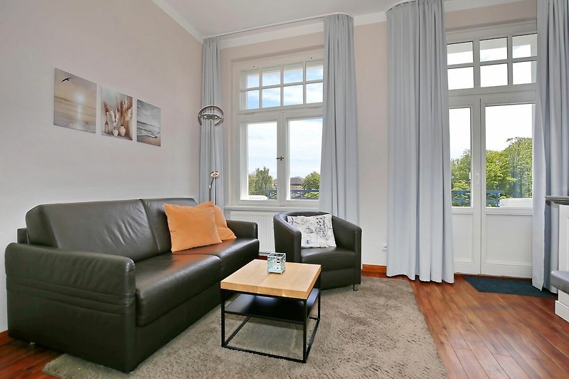 Wohnzimmer mit Schlafcouch und Sessel