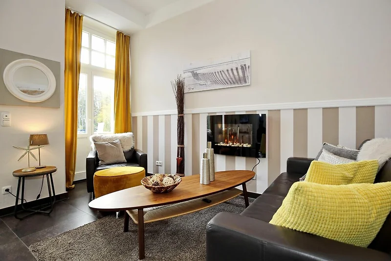 Wohnzimmer mit Sitzecke und Elektrokamin
