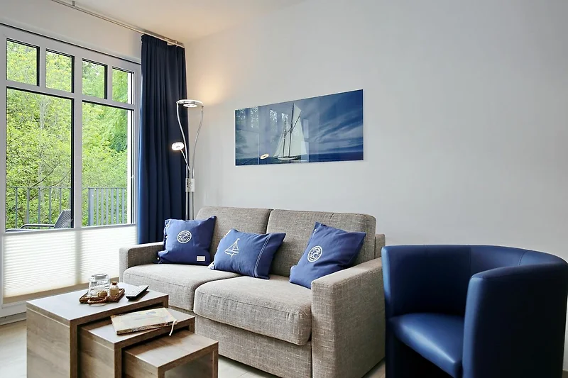 Wohnzimmer mit Schlafcouch und Sessel