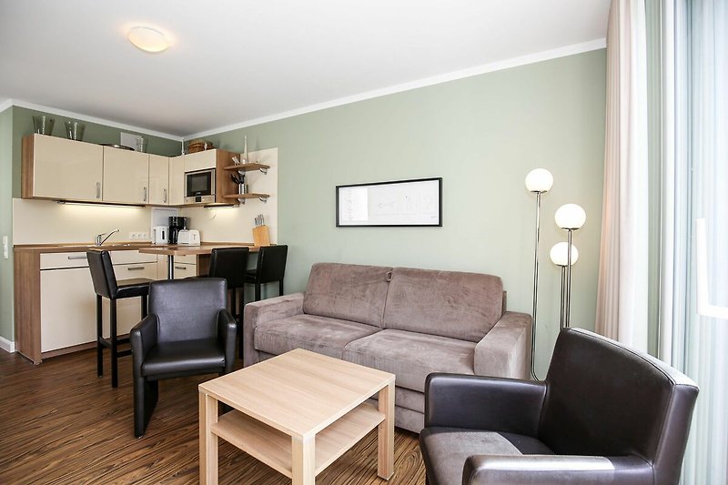 Wohnzimmer mit Schlafcouch und Küchenzeile