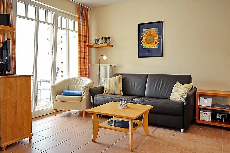 Wohnzimmer mit Schlafcouch und Sessel