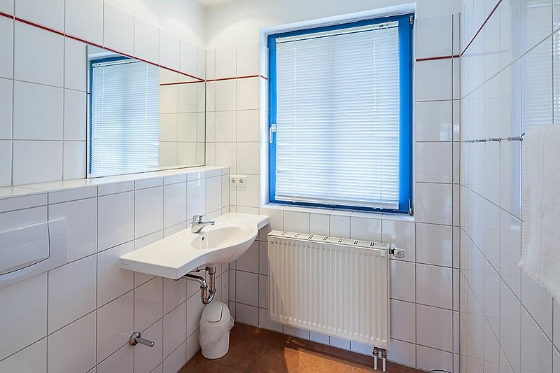 Badezimmer mit Waschbecken und Fenster