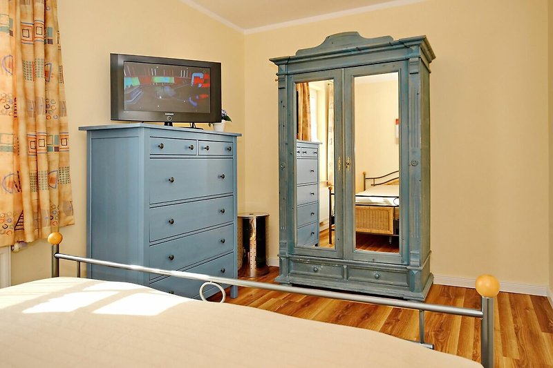 Schlafzimmer mit Kleiderschrank, Kommode und TV