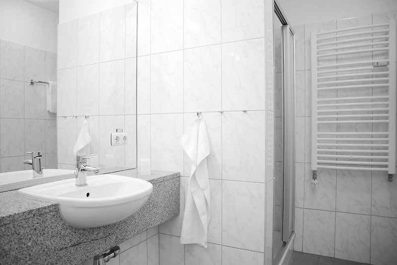 Badezimmer mit Dusche und Handtuchheizung