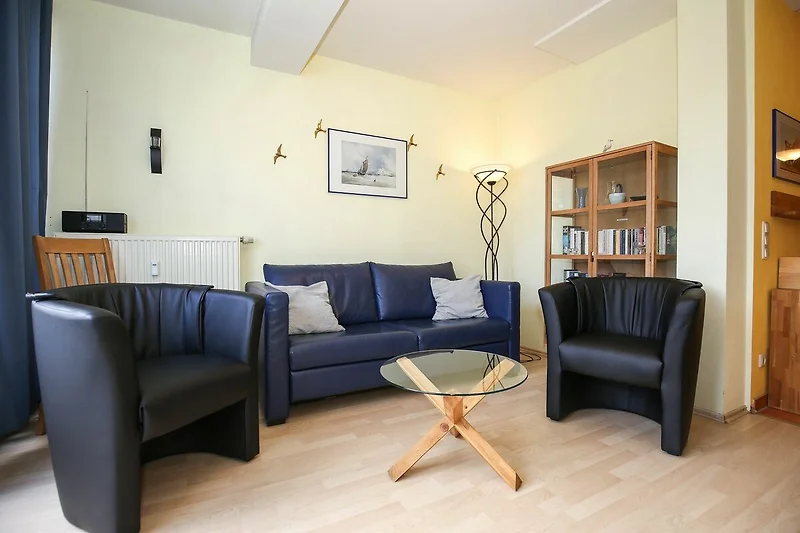 Wohnzimmer mit Schlafcouch und Sesseln