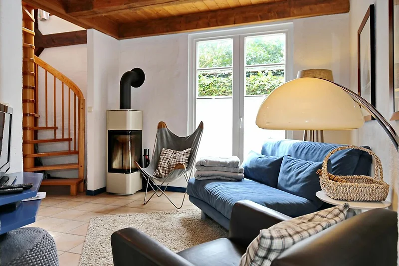 Wohnzimmer mit Schlafcouch und Kamin