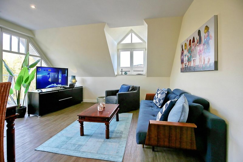 Wohnzimmer mit Sofa, Sessel und TV
