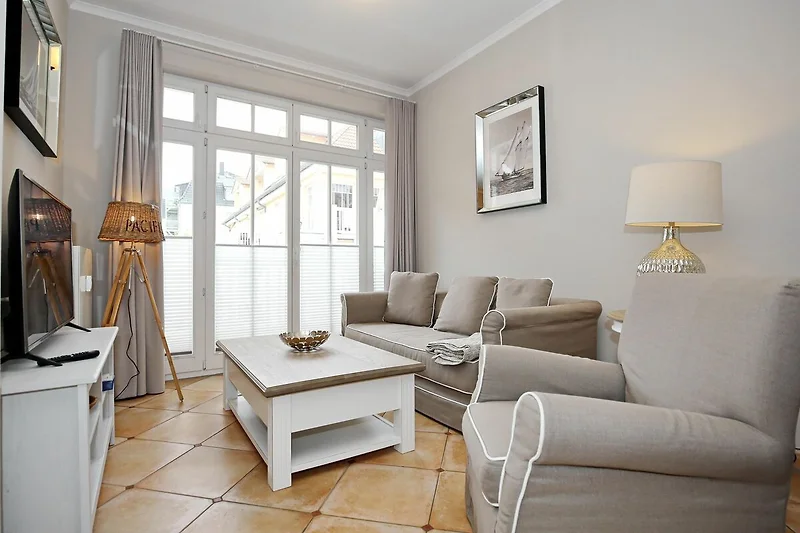 Wohnzimmer mit Schlafcouch und Sessel