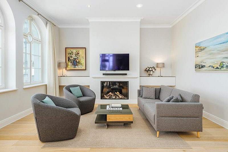Wohnbereich mit Couch, Sesseln und TV
