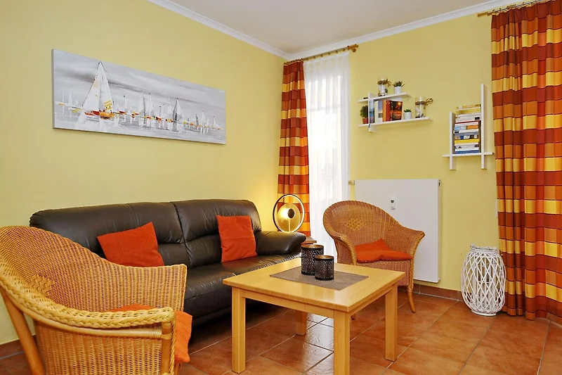 Wohnzimmer mit Couch und Korbsesseln