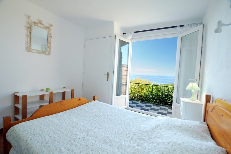 Détendez-vous dans cette chambre confortable avec vue sur mer et profitez du mobilier en bois.